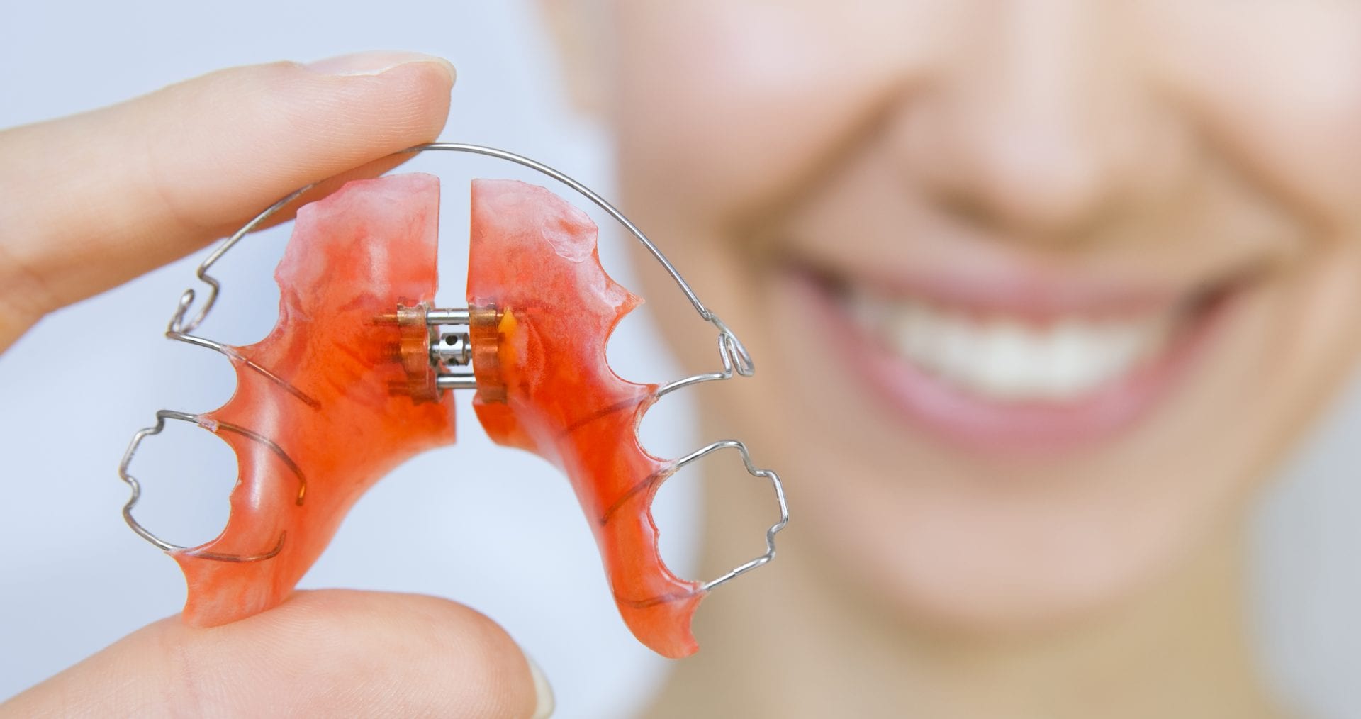 Girl holding retainer for teeth | Crane & Seager Orthodontics in Fort Collins and Loveland, CO